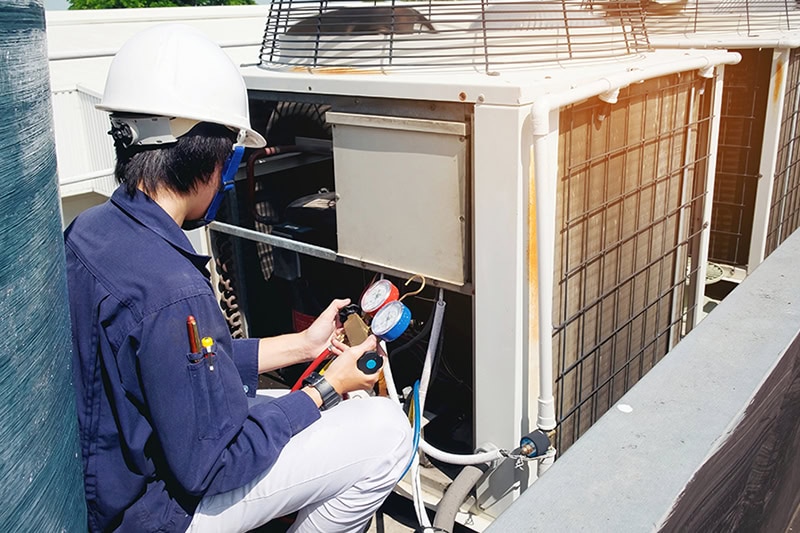 Why Is a Commercial AC Tune-Up Important? A technician working on an HVAC unit.